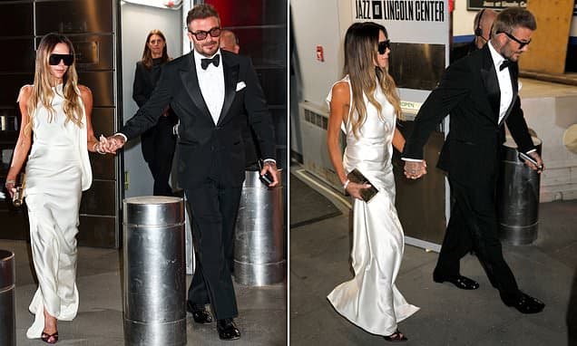 Victoria Beckham cuts an elegant display in a silk gown as she and husband David hold hands outside the TIME100 Gala in New York