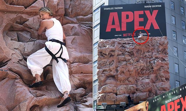 Charlize Theron overcomes her fear of heights as she scales climbing wall set into a giant billboard in Times Square to promote new film