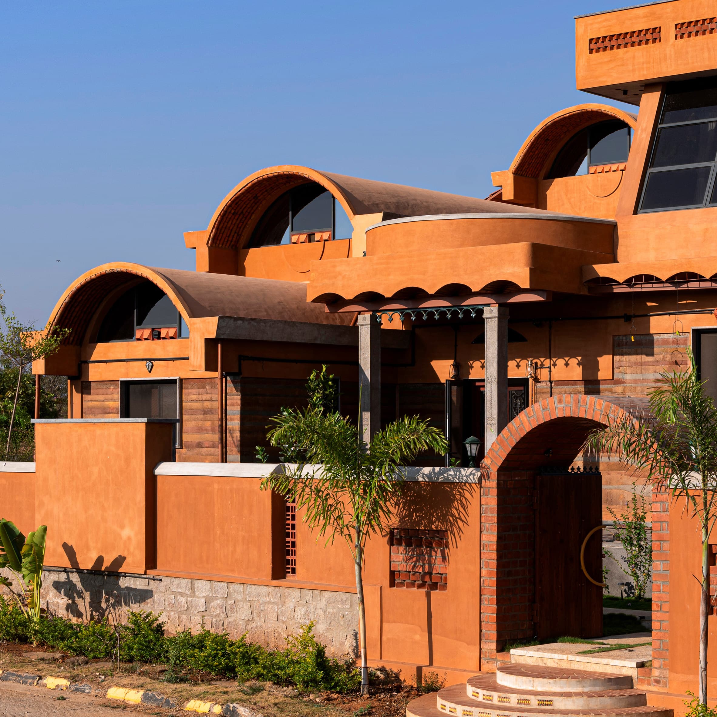 Iki Builds uses local stone and earth for "cascading" vaulted home in India